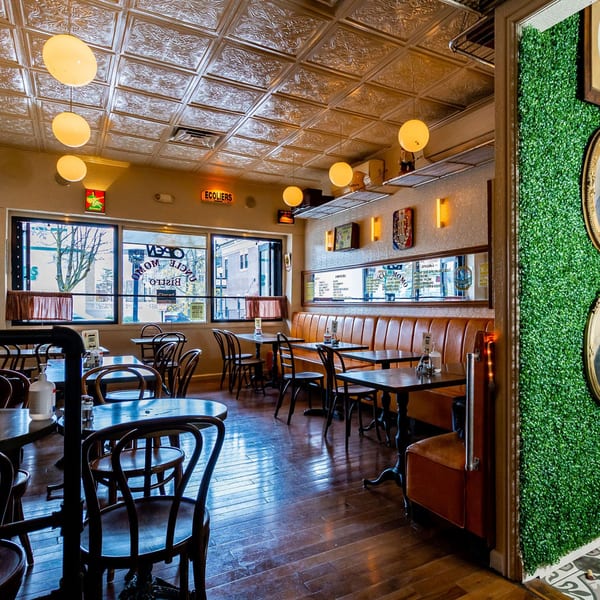 Interior of Uncle Momo, a Lebanese restaurant, with tables, chairs, and a long booth.