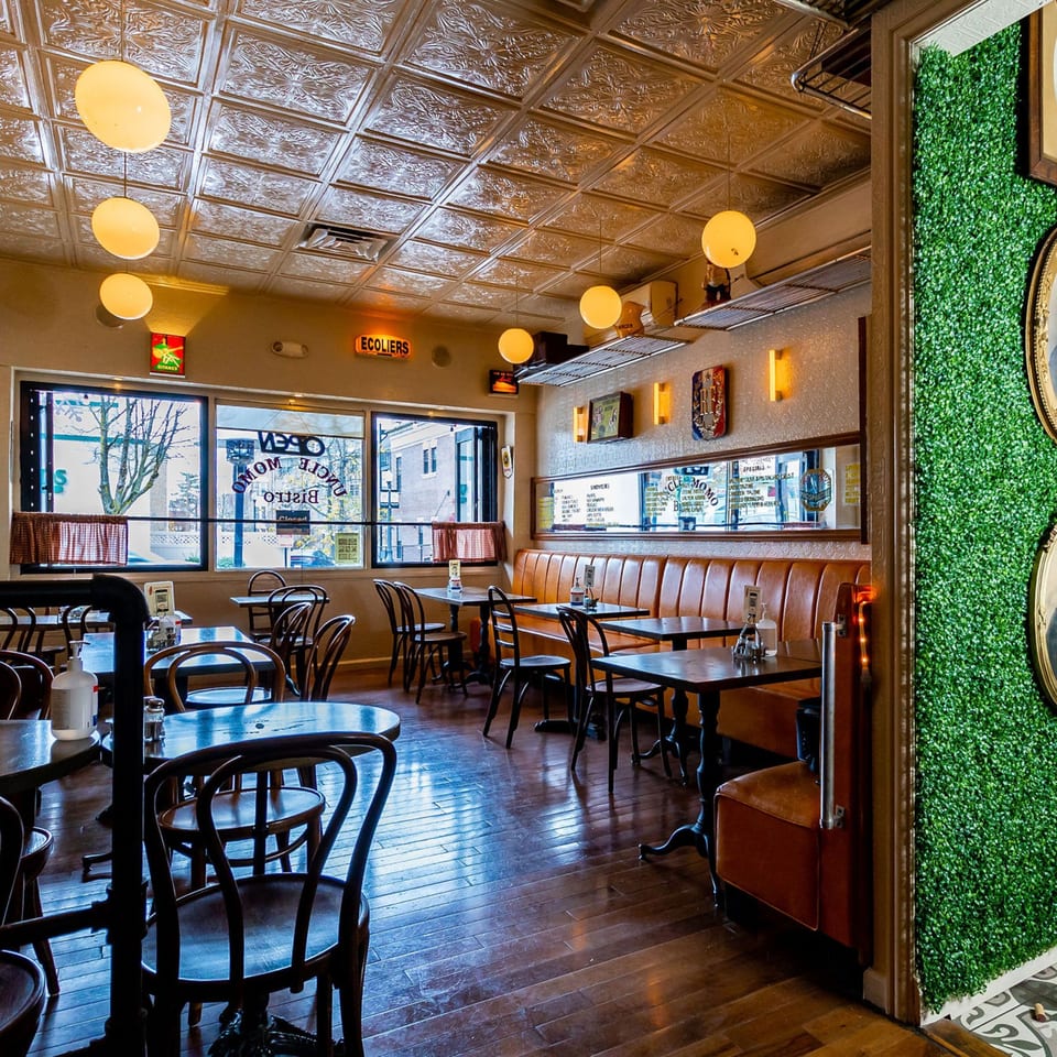 Interior of Uncle Momo, a Lebanese restaurant, with tables, chairs, and a long booth.